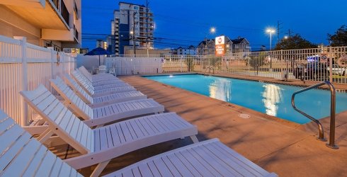 Outdoor pool at night with lounge chairs